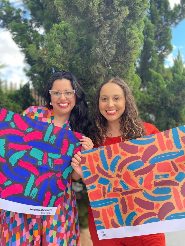 Duas amigas segurando suas cartelas de cores